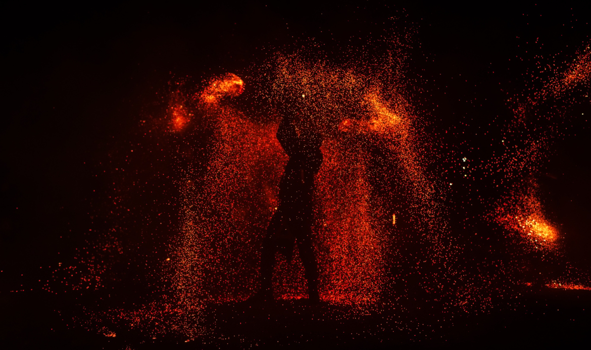 Fire show, dancing with flame, male master juggling with fireworks, performance outdoors,