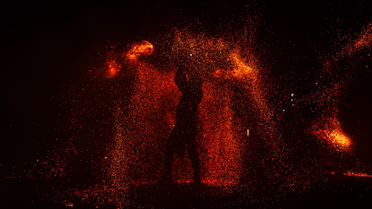 Fire show, dancing with flame, male master juggling with fireworks, performance outdoors,