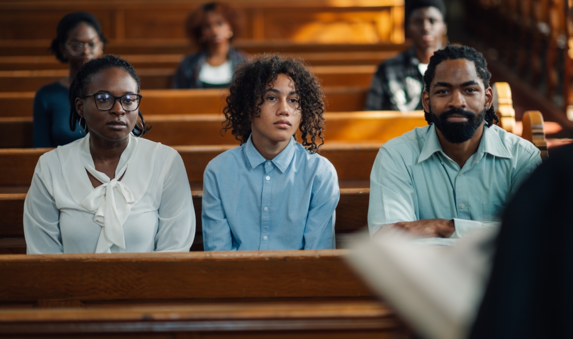 Family sitting in church pew listening to sermon