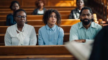 Family sitting in church pew listening to sermon