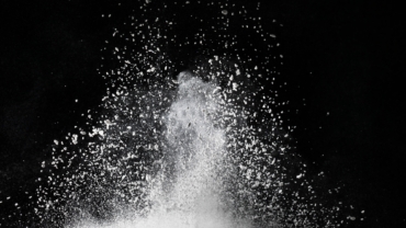 White dust exploding on surface impact